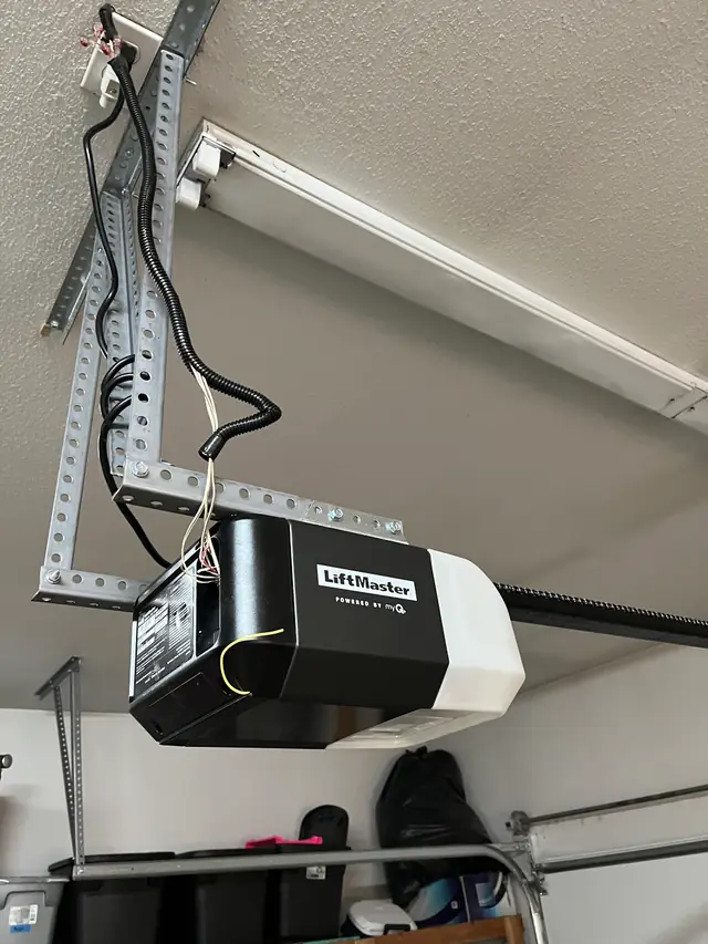 A LiftMaster belt-drive opener head mounted on a ceiling angle in a garage
